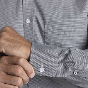 A men's button-up shirt featuring a small check pattern in grey, with a front pocket and buttoned cuffs.