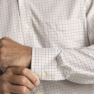 A button-up shirt featuring a check pattern in white, blue, and tan, with a pocket and cuffed sleeves.