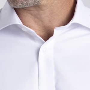 A white button-up shirt with a collar, featuring a subtle texture and a logo on the chest area.