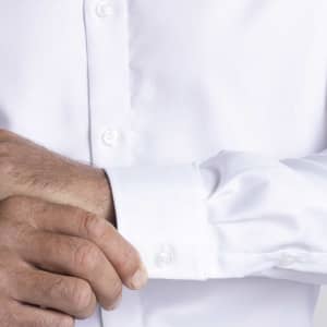 A men's white button-up shirt with a close-up of the cuff and buttons, featuring a logo.