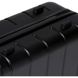 A black hardcase trolley with ridged design, featuring multiple zippers and handles.