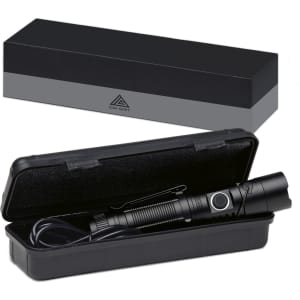 A black torch is inside a hard case, displayed with a sleek black box in the background. The torch has a clip and button.