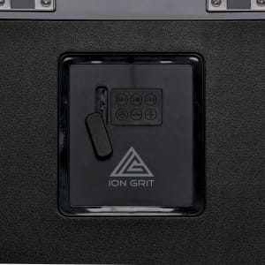 A black sound box with a control panel featuring buttons and a plug-in compartment, along with a logo.