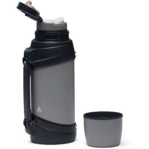 A drink bottle in grey with a black, textured grip and a matching cup beside it. The bottle has a lid with a spout and a logo.