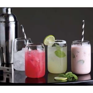 A selection of mixed drinks in glassware, featuring vibrant colours and garnishes, with a cocktail shaker in the background.