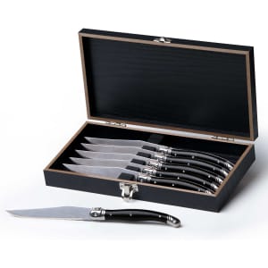 A set of six stainless steel knives with black handles, housed in a sleek black wooden case.