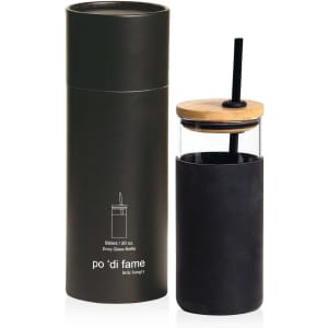 A drink bottle with a clear glass body, black silicone sleeve, and wooden lid, presented in a cylindrical black container.