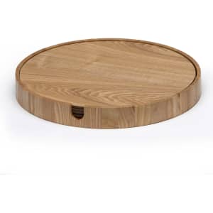A round wooden placemat in a light timber finish, featuring a smooth surface and a groove design around the edge.