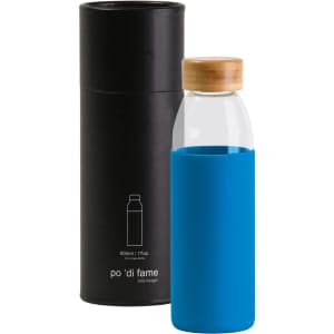 A drink bottle with a clear glass body, blue silicone sleeve, and wooden lid, presented in a black cylindrical box.