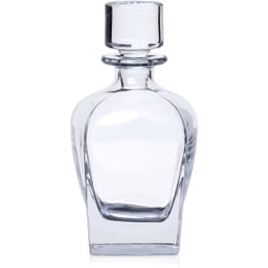 A clear glass whisky decanter with a round stopper, featuring a simple, elegant design.