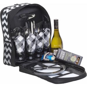 A picnic set featuring a black and white chevron bag, wine bottle, glassware, cutlery, and dinner plates.