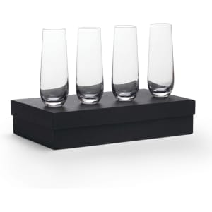 Four clear glass stemless champagne flutes displayed on a black box.