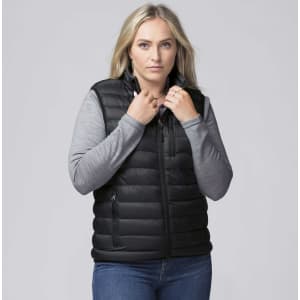 A woman wearing a black padded baffle vest over a grey long-sleeve top, with her hands at the collar.