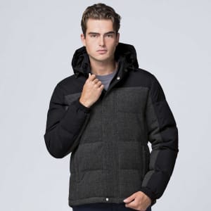 A man wearing a black and grey jacket with a hood, featuring a quilted design and elastic cuffs. There's a logo on the jacket.