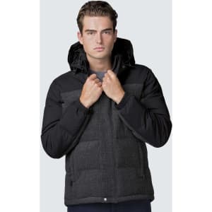 A man models a black and grey smpli XT Plunge Jacket with a hood, featuring a zip front and multiple pockets.