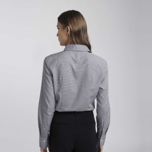 A women's button-up shirt in light grey with long sleeves and a collar, featuring a logo on the back.