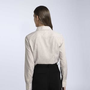 A women's button-up shirt in a cream and brown check pattern, featuring a collar and long sleeves.
