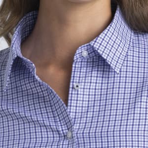 A close-up of a women's button-up shirt featuring a purple and white check pattern, with a collar and buttons.