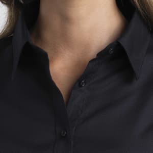 A close-up of a women's button-up shirt in black featuring a collar and button detailing.