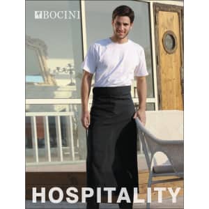A man in a black cotton drill apron stands outside, showcasing a simple, pocketless design. The apron has a logo.