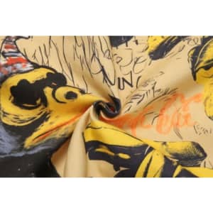 A fabric featuring a vibrant design with black and yellow illustrations on a tan background, including whimsical characters.