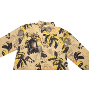 A long-sleeve shirt with a yellow banana and monkey pattern on a beige background, featuring various artistic designs.