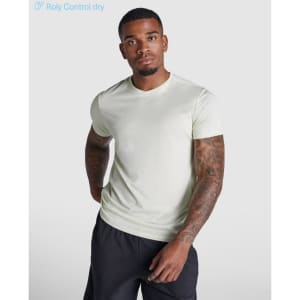 A light green t-shirt with short sleeves, featuring a logo, modelled by a person with tattoos.