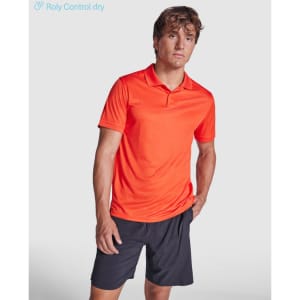 An orange polo shirt on a model, paired with black shorts, featuring a logo on the left side.