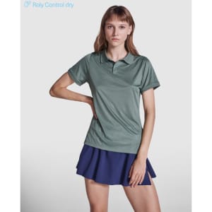 A women's polo shirt in a muted green colour with a logo, paired with a navy skirt.