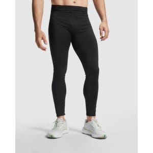 Black men's leggings with a fitted design, complemented by a white branded logo, and styled with light athletic shoes.