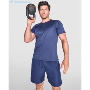 A man in a navy blue T-shirt and shorts holding a kettlebell, showcasing activewear for fitness.