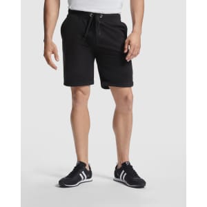 Black sports shorts with an elastic waistband and drawstring, featuring pockets and paired with black sneakers.
