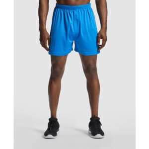 Blue sports shorts with an elastic waistband, featuring a logo on the side, displayed on a model.