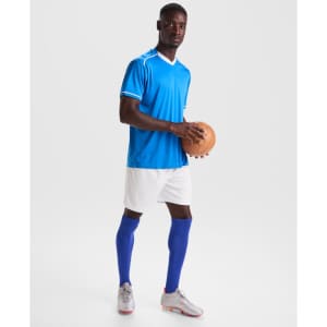 A male athlete wearing a blue sports jersey, white shorts, and blue knee-high socks, holding a brown sports ball.