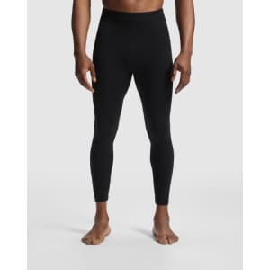 A pair of black leggings designed for men, featured on a model standing barefoot. The product has a logo detail.
