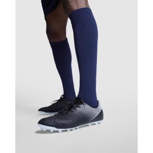 Navy blue soccer sport socks are worn above black soccer cleats, featuring a textured design and a logo.