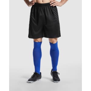 A pair of black goalkeeper shorts with a logo, paired with blue knee socks and black footwear.