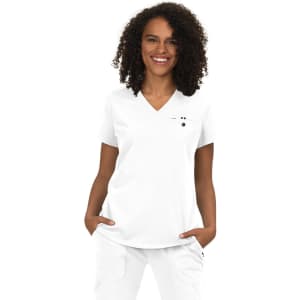 A white v-neck top worn by a woman with curly hair, featuring a logo on the chest pocket.