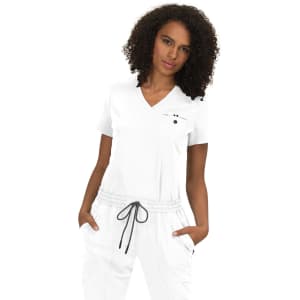 A woman wearing a white top with a V-neck and grey drawstring pants, featuring a logo on the top.