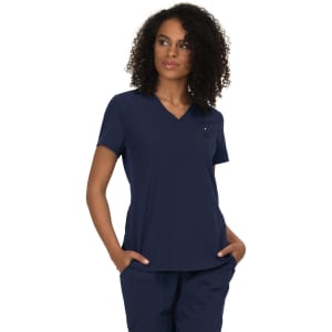 A navy blue v-neck top with short sleeves and a small logo, modelled by a woman with curly hair.