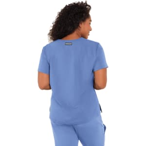 A woman wearing a blue top, showcasing the back design. The top features a logo on the upper back.