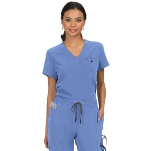 A woman wearing a light blue scrubs top with a v-neck and a small logo on the chest.