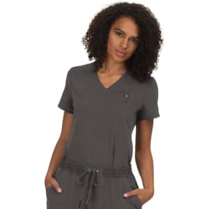 A woman wearing a grey V-neck top with a loose fit and short sleeves, featuring a small logo.