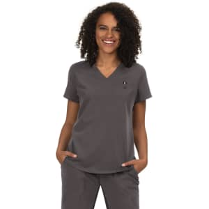 A woman wearing a grey top with a V-neck and short sleeves, featuring a small logo on the chest.
