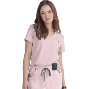 A light pink top with short sleeves and a V-neck, featuring a small logo and pockets.