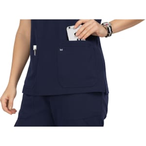 A navy blue top with pockets, featuring a hand reaching for a phone in one pocket. It has a logo on the fabric.