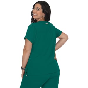 A back view of a woman wearing a green scrubs top, featuring a simple design and a branding logo.