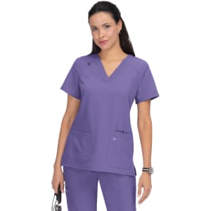 A purple medical scrub top with a v-neck design. It features two front pockets and has a logo.