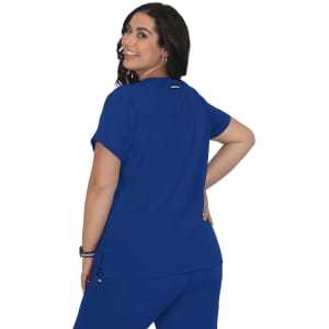 A woman is wearing a blue short-sleeved top, showing the back view. The top has a logo.