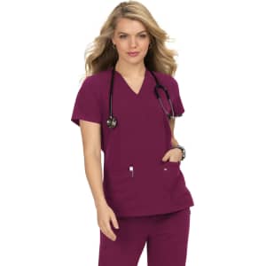 A woman wearing a purple scrubs top with a V-neck and pockets, paired with a stethoscope around her neck.